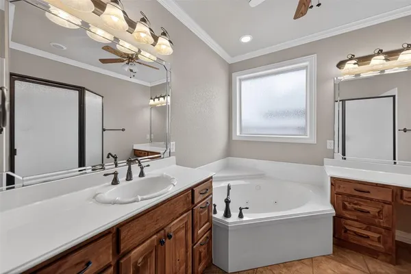 a bathroom with a tub a double vanity sink and a mirror