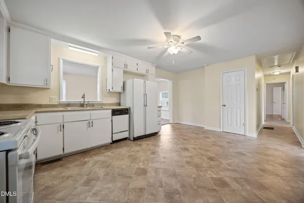 a kitchen with white cabinets and white appliances