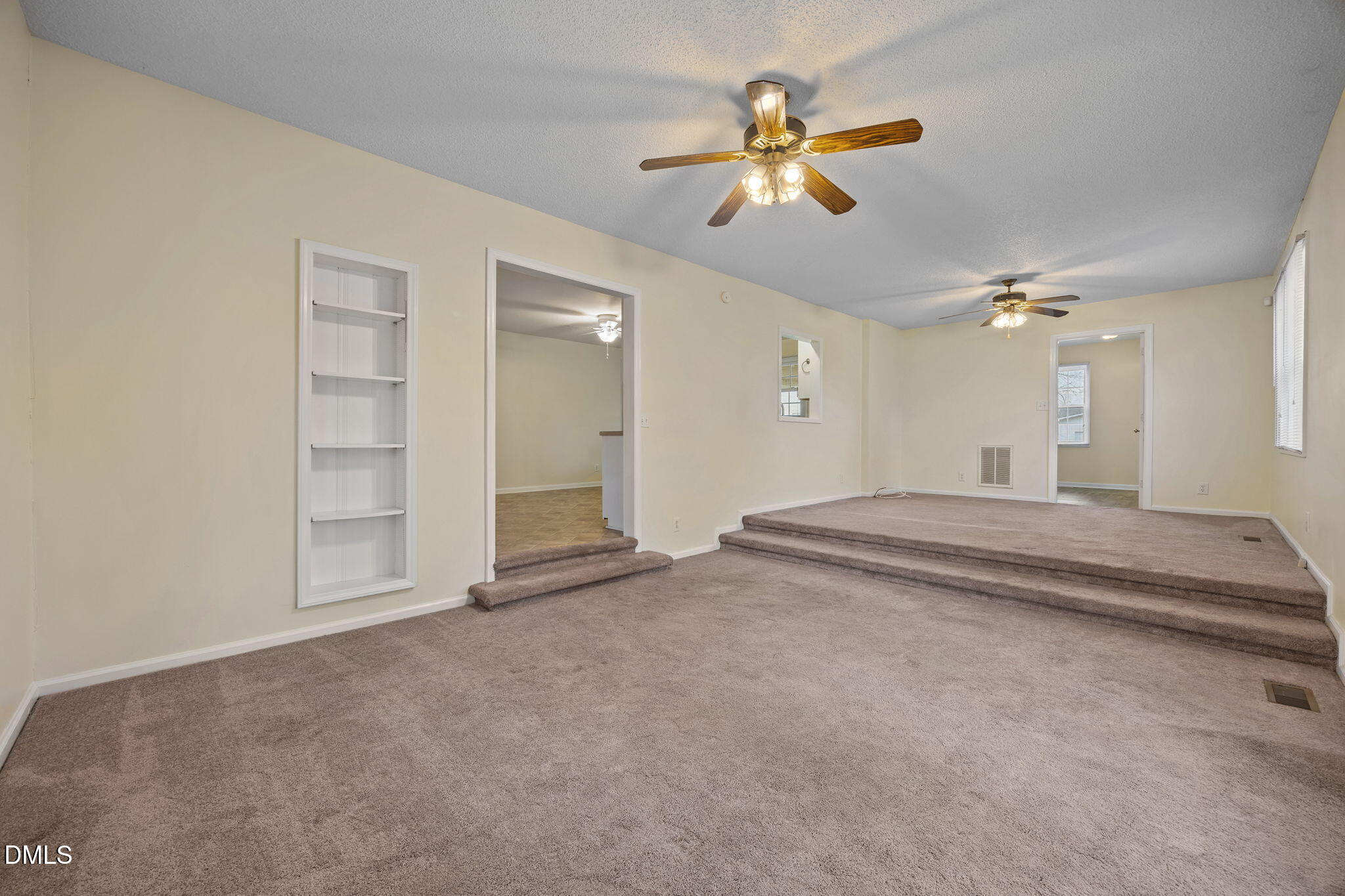 131 Fairview Village Road Dunn, NC 28334 - Photo 22 of 43 an empty room with chandelier fan and kitchen view