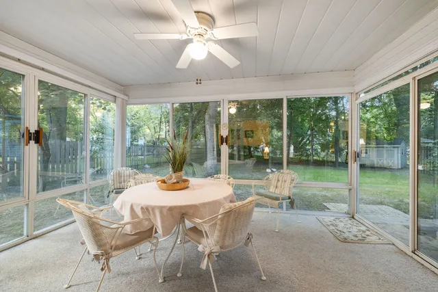 a dining room with furniture water view and a floor to ceiling window