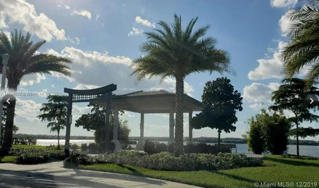 a view of a house with a yard and palm trees