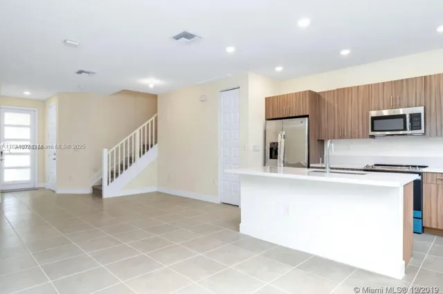 a view of kitchen with stainless steel appliances a sink and a refrigerator