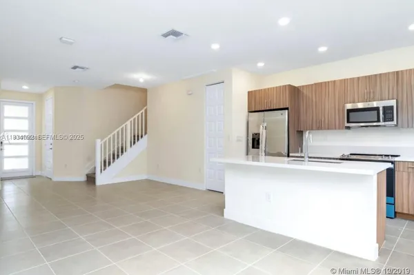 a view of kitchen with stainless steel appliances a sink and a refrigerator