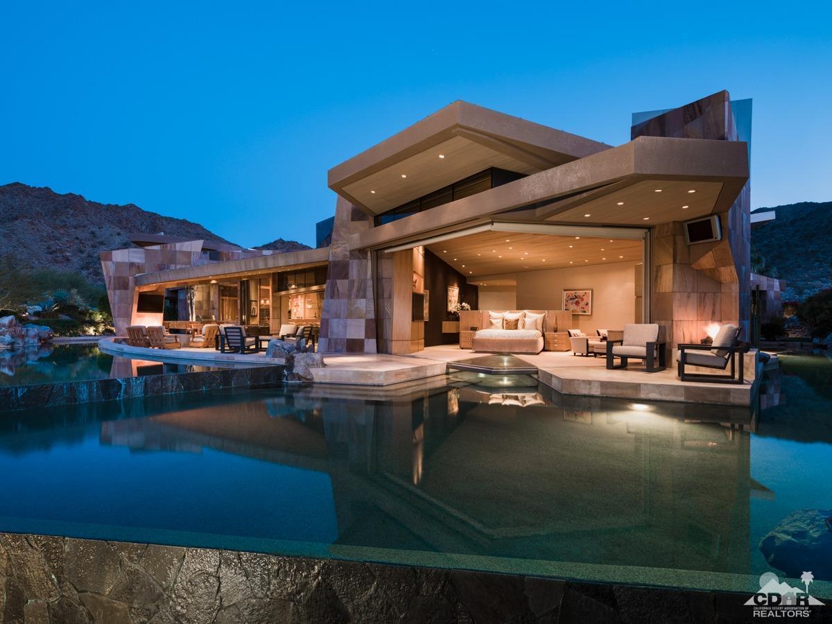 632 Pinnacle Crest Palm Desert, CA 92260 - Photo 2 of 52 a view of a swimming pool with a table and chairs under an umbrella