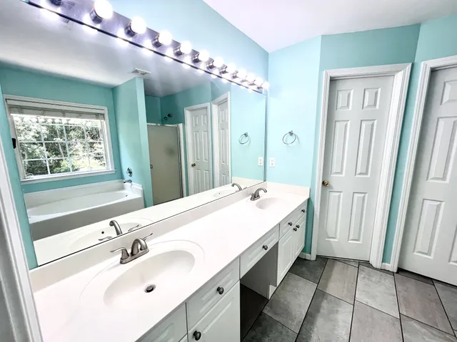 a bathroom with a double vanity sink and a mirror