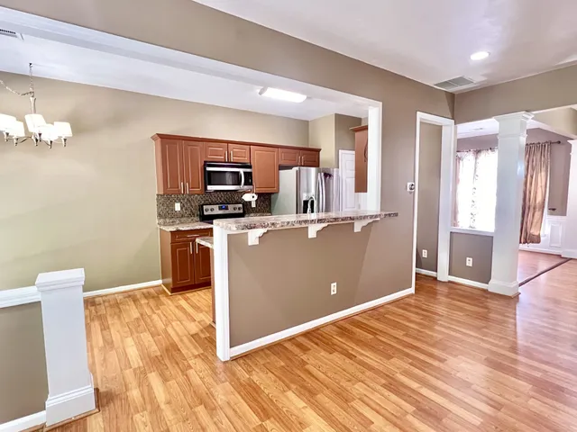 a kitchen with stainless steel appliances granite countertop a stove a sink and a refrigerator