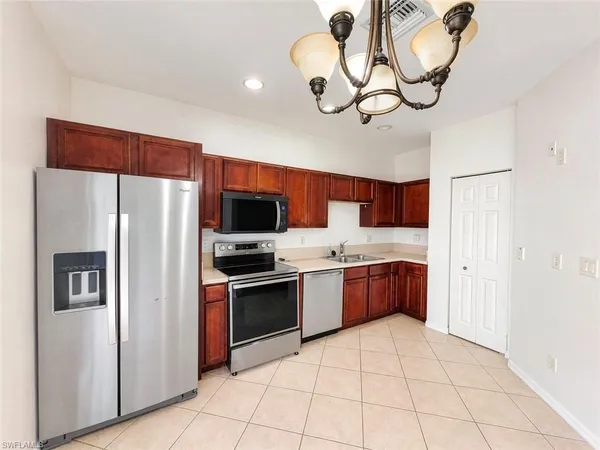 a kitchen with stainless steel appliances granite countertop a refrigerator a stove top oven a sink and dishwasher