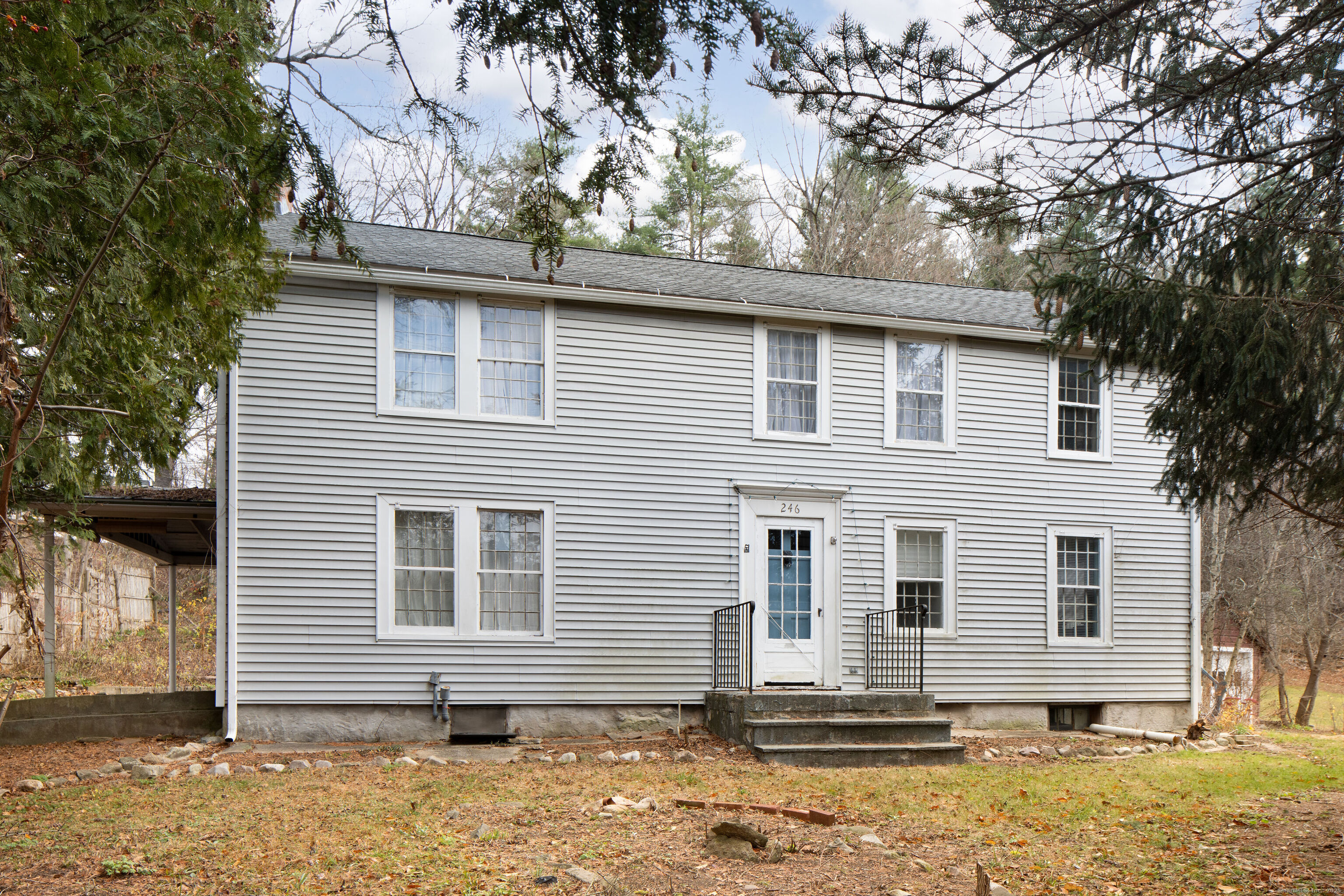 a side view of a house with a tree