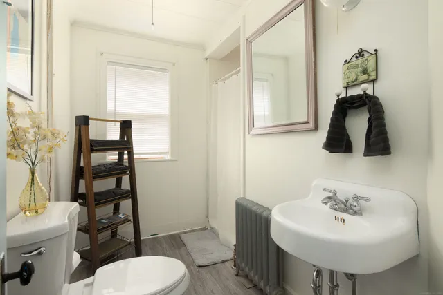 a bathroom with a sink toilet and a mirror