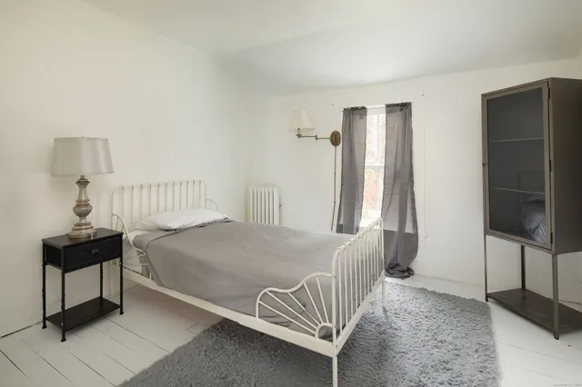 a bedroom with a bed and a lamp on table