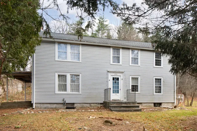 a side view of a house with a tree