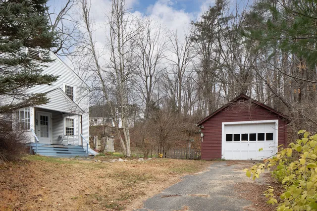 a white house that has a tree in front of it