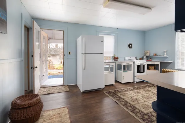 a view of a kitchen with furniture and wooden floor