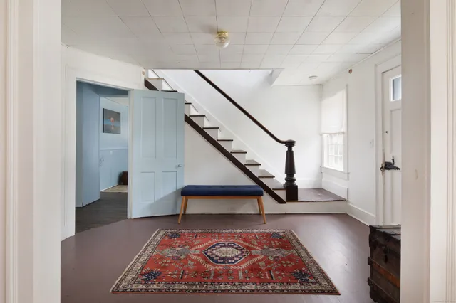 a view of entryway and hall with wooden floor