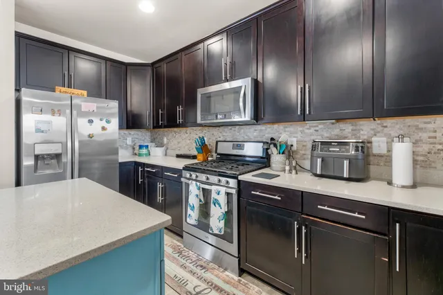 a kitchen with granite countertop stainless steel appliances and wooden cabinets
