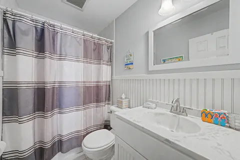 a bathroom with a sink a toilet and a shower