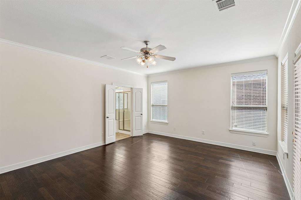 960 Remuda Road Frisco, TX 75033 - Photo 24 of 39 Spacious room featuring dark wood-finish flooring, light neutral walls, a ceiling fan with integrated lighting, and multiple windows with blinds
