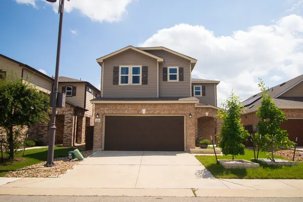 a front view of a house with a yard and garage