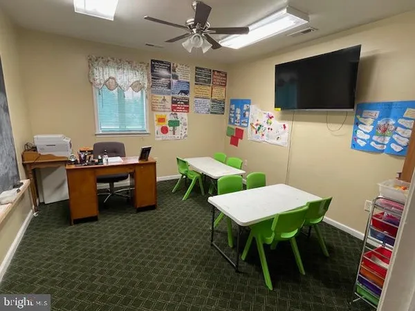 a outdoor kitchen with a table chairs and a flat screen tv