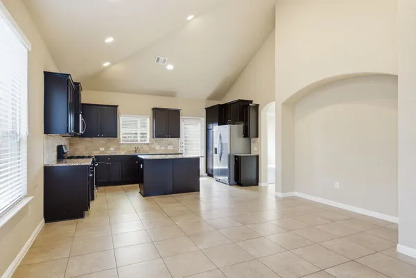 a large kitchen with a large counter top and stainless steel appliances