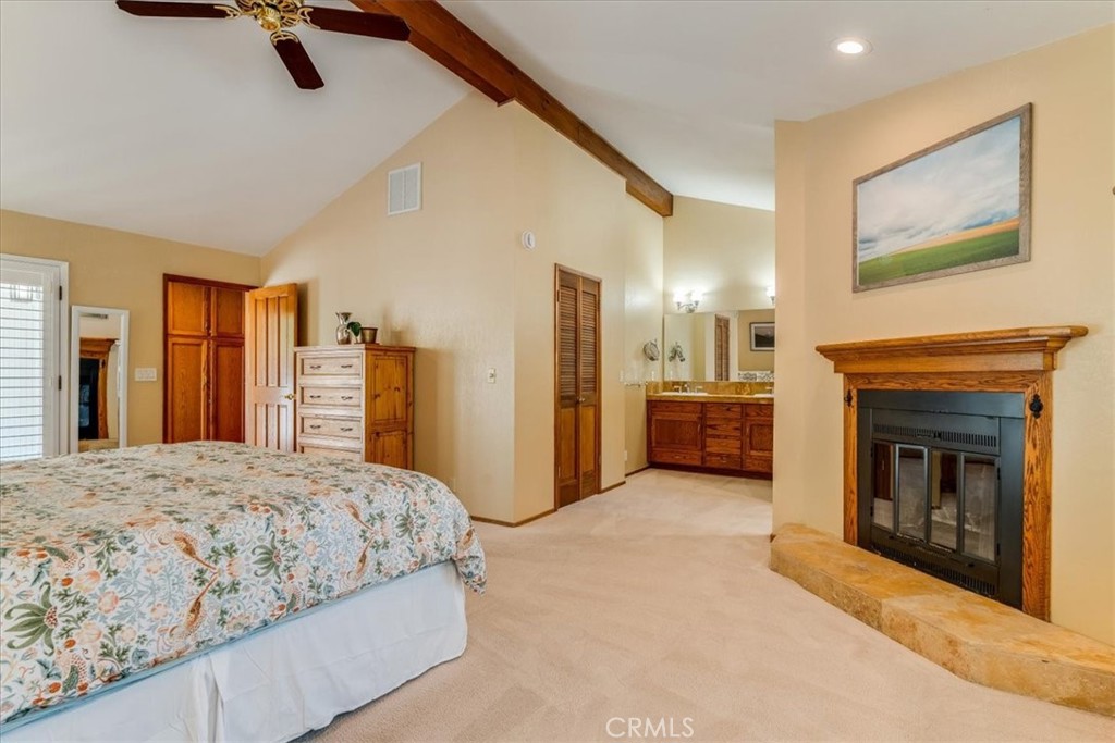 11555 Cenegal Road Atascadero, CA 93422 - Photo 28 of 57 a spacious bedroom with a bed and a fireplace