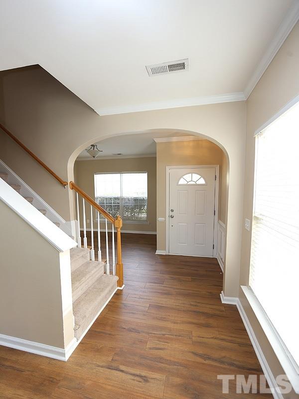 8336 Tie Stone Way Raleigh, NC 27613 - Photo 2 of 20 a view of a hallway with wooden floor and stairs