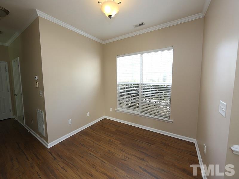 8336 Tie Stone Way Raleigh, NC 27613 - Photo 3 of 20 a view of an empty room with wooden floor and a window