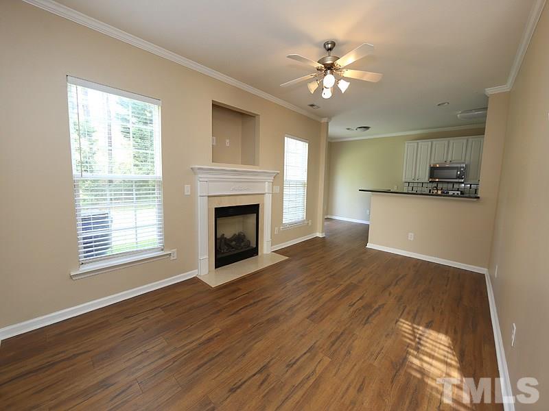 8336 Tie Stone Way Raleigh, NC 27613 - Photo 4 of 20 a view of an empty room with wooden floor fireplace and a window