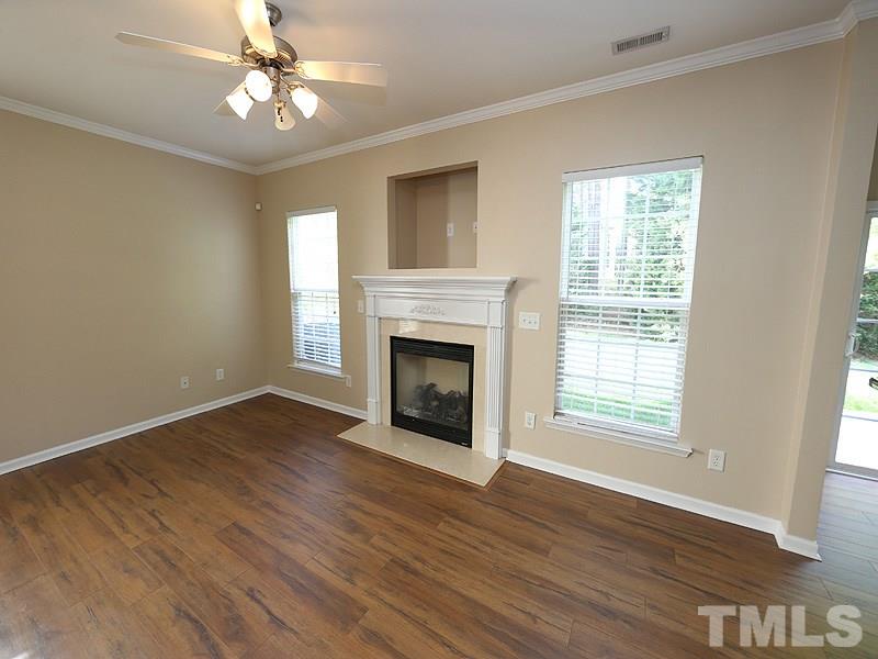 8336 Tie Stone Way Raleigh, NC 27613 - Photo 5 of 20 a view of an empty room with wooden floor fireplace and a window