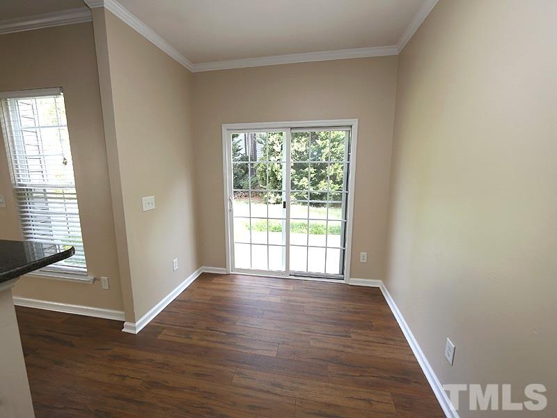 8336 Tie Stone Way Raleigh, NC 27613 - Photo 7 of 20 a view of an empty room with wooden floor and a window