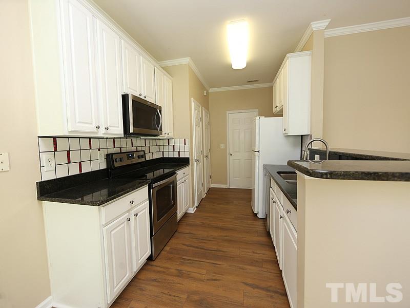 8336 Tie Stone Way Raleigh, NC 27613 - Photo 8 of 20 a kitchen with a sink and a stove top oven