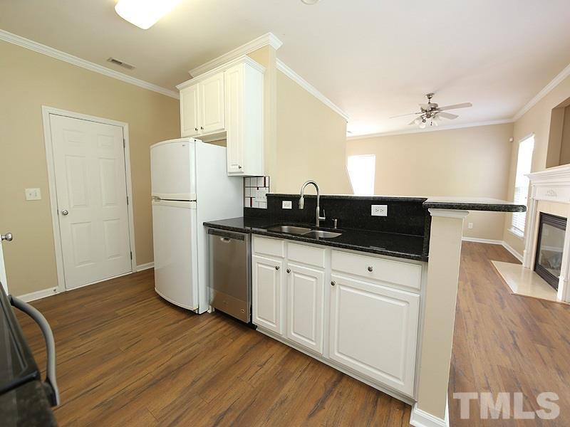 8336 Tie Stone Way Raleigh, NC 27613 - Photo 9 of 20 a kitchen with a refrigerator a sink and wooden floor