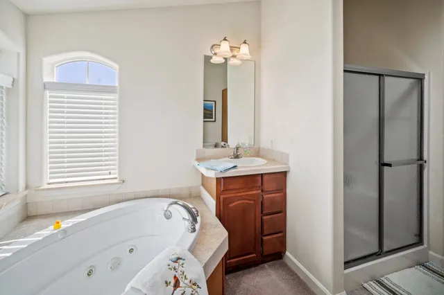 a bathroom with a tub sink and mirror