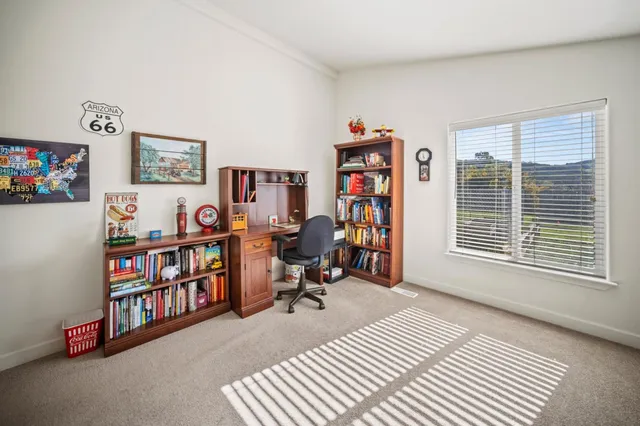 a view of a workspace with furniture and a window