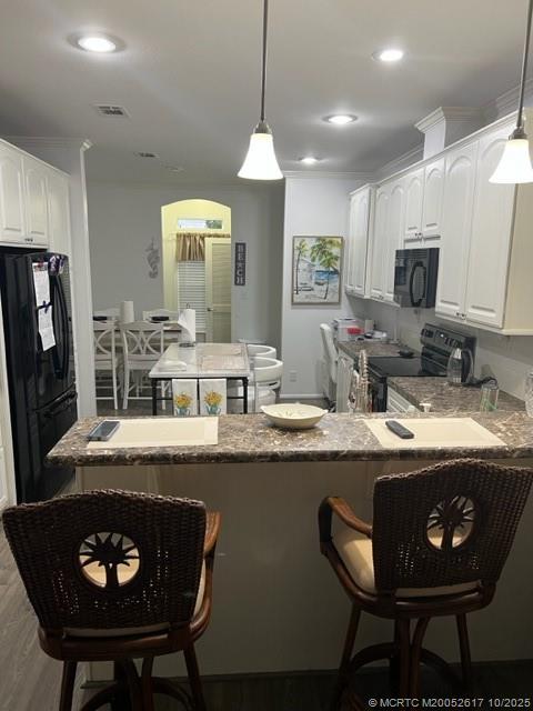 4191 2nd Court Lantana, FL 33462 - Photo 4 of 12 a kitchen with stainless steel appliances granite countertop a stove a sink a microwave a dining table and chairs