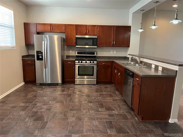 a kitchen with stainless steel appliances granite countertop a stove a refrigerator and a sink