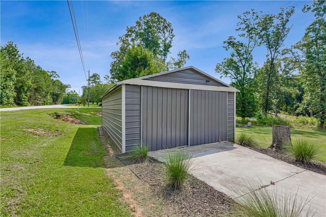 842 Conneross Road Townville, SC 29689 - Photo 25 of 34 A durable metal outbuilding offers practical storage solutions amidst a natural, treed landscape.