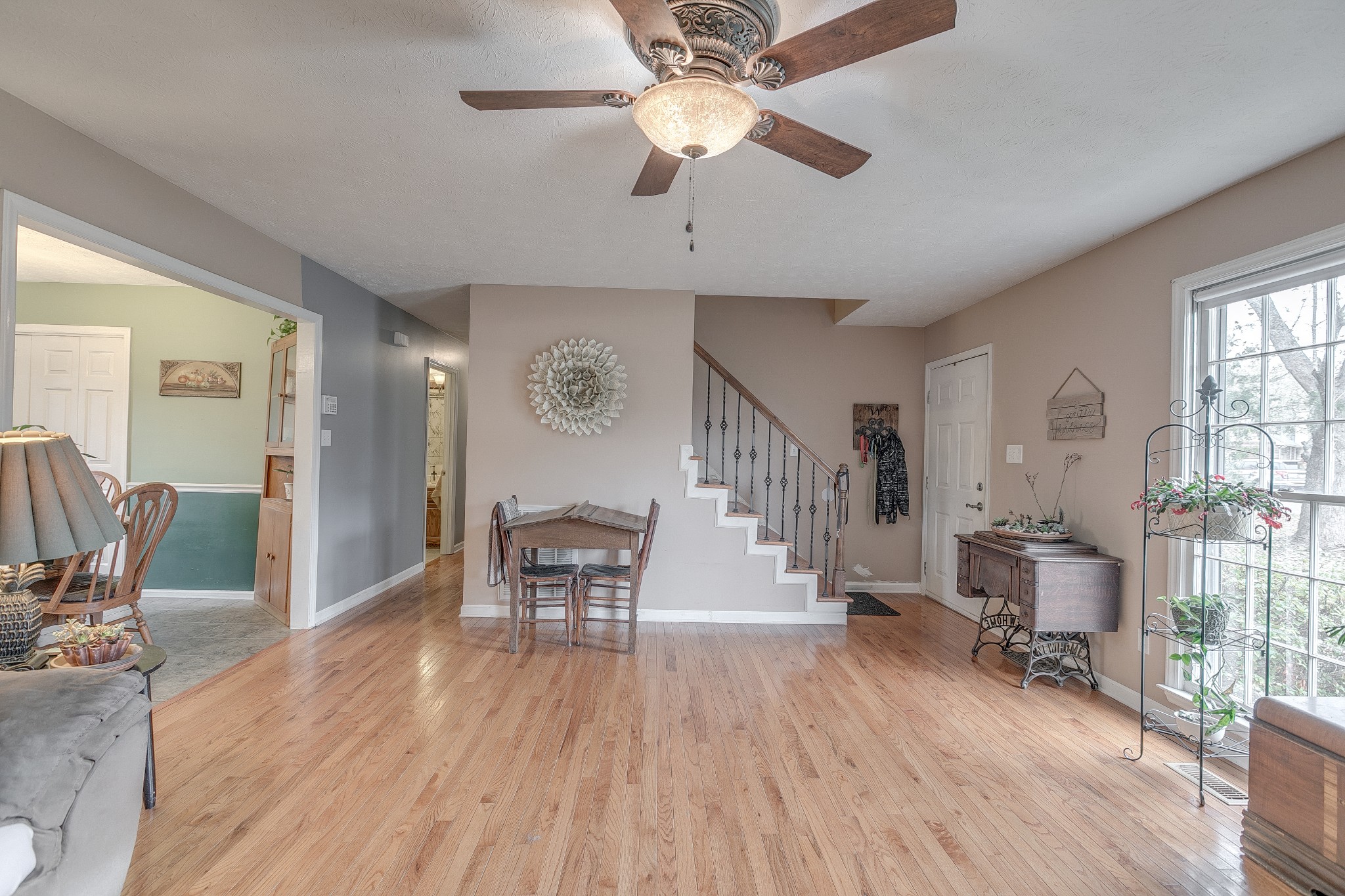 3385 Ridgefield Drive Murfreesboro, TN 37129 - Photo 6 of 25 a dining room with wooden floor a chandelier fan a wooden table and chairs