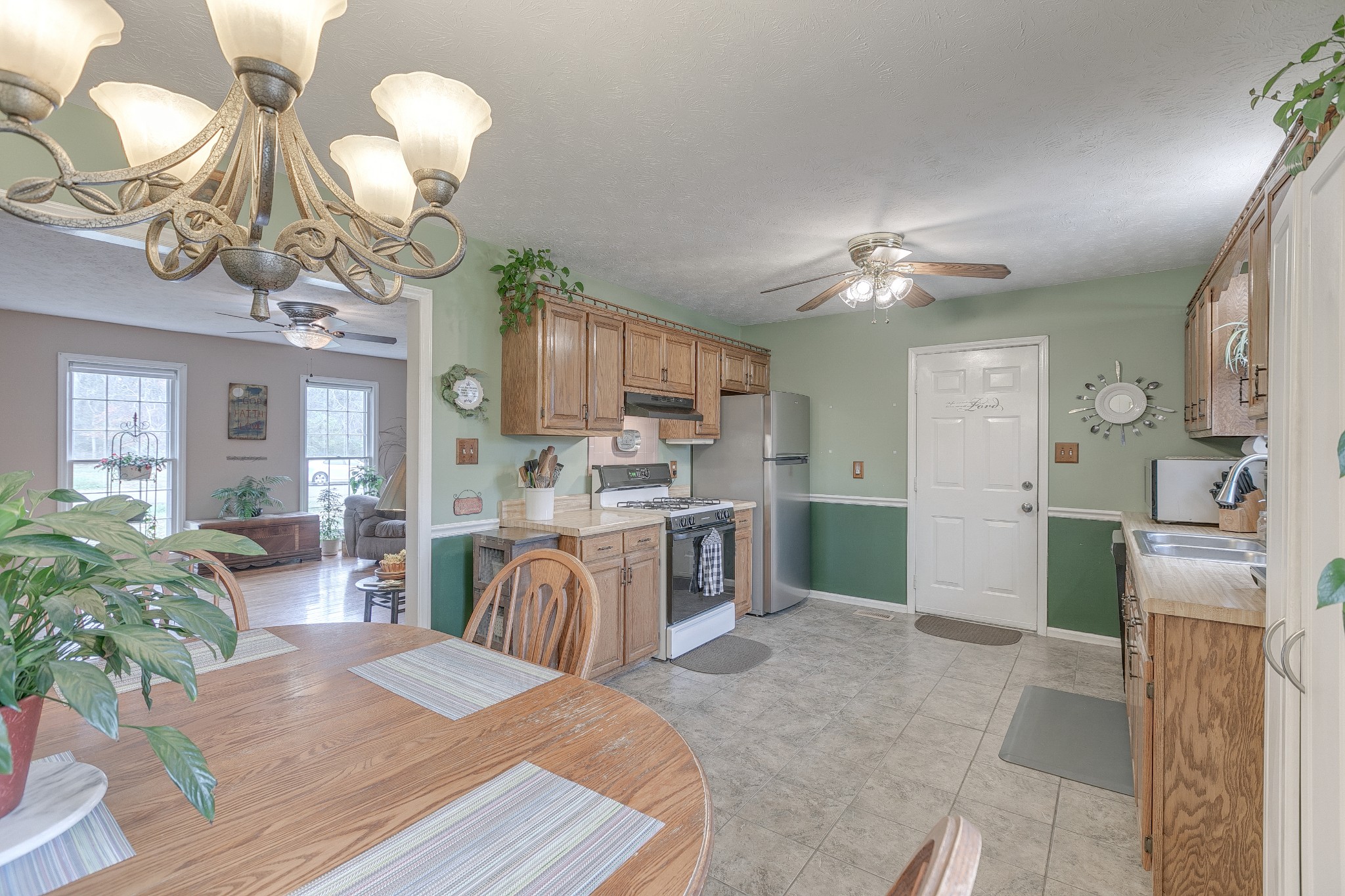 3385 Ridgefield Drive Murfreesboro, TN 37129 - Photo 7 of 25 a kitchen view with stainless steel appliances a stove refrigerator a sink dishwasher a dining table and chairs with wooden floor
