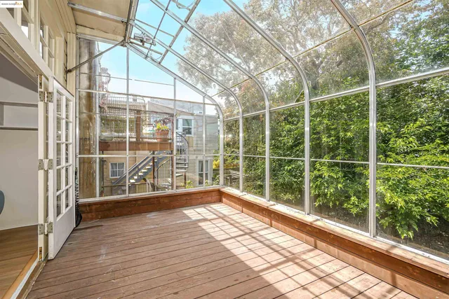 a view of empty room with wooden floor and iron fence