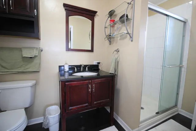 a bathroom with a sink vanity mirror and toilet