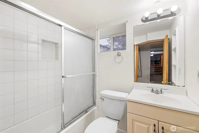 a bathroom with a toilet sink vanity and mirror