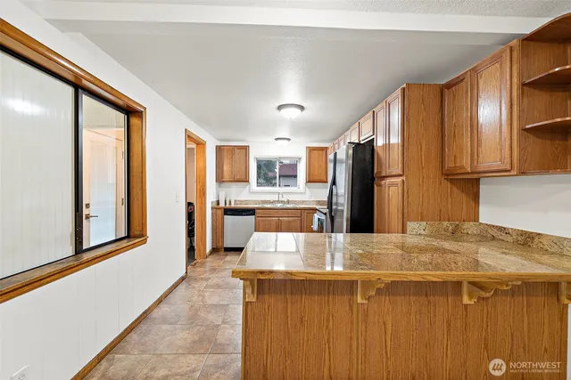 a kitchen with stainless steel appliances kitchen island granite countertop a refrigerator and cabinets