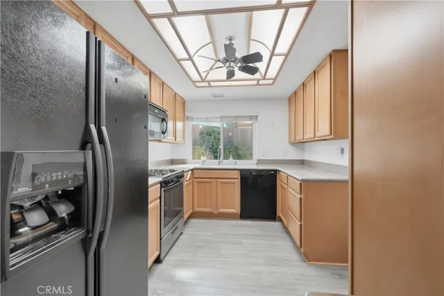 a kitchen with stainless steel appliances granite countertop a sink a stove a refrigerator and cabinets