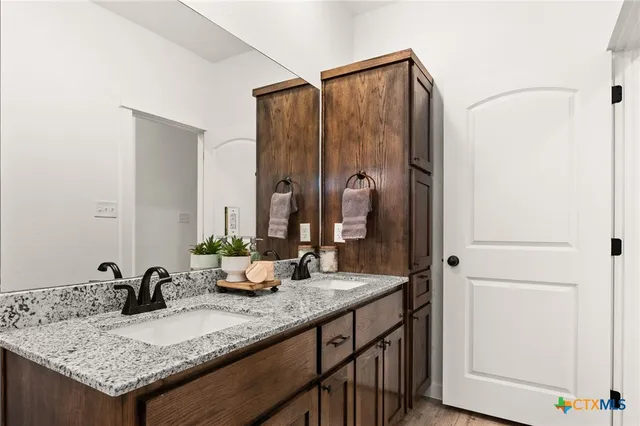 a bathroom with a granite countertop sink and a mirror