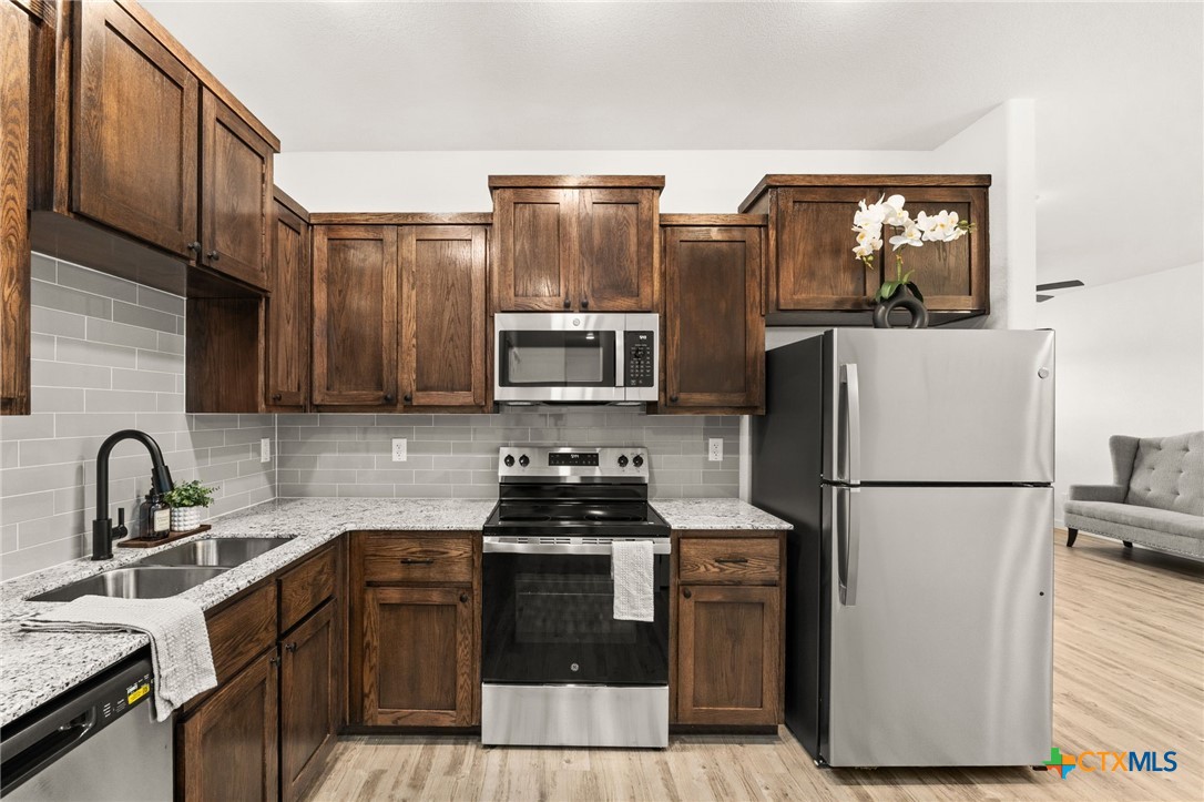 3602 Canvasback Road, Unit A Killeen, TX 76542 - Photo 9 of 29 a kitchen with stainless steel appliances a refrigerator stove and sink