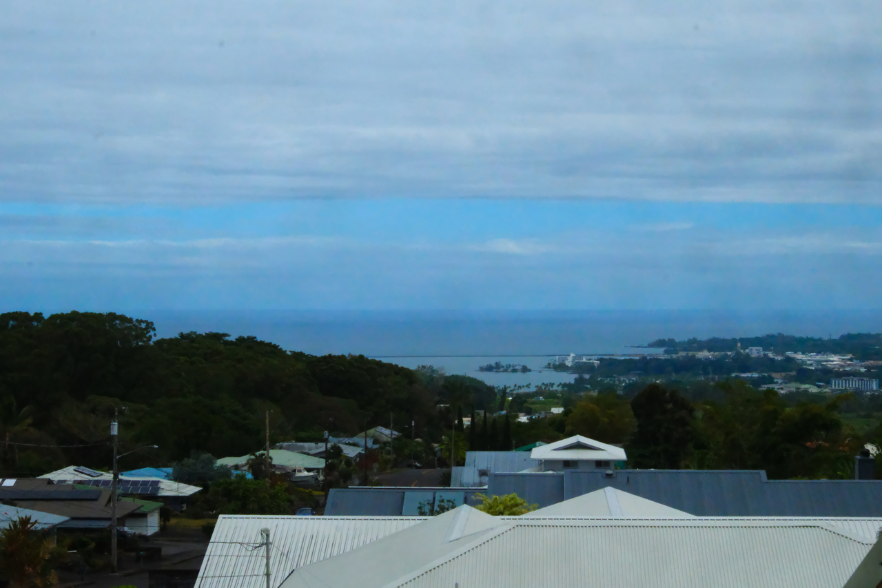 883 Hele Mauna Street Hilo, HI 96720 - Photo 2 of 26 a view of a terrace with a table and chairs under an umbrella