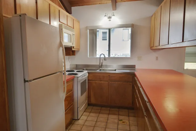 a kitchen with a refrigerator sink and cabinets