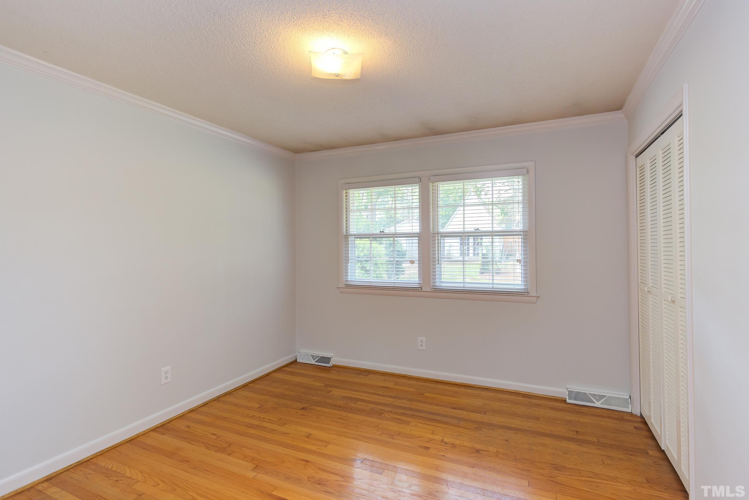 2312 Gresham Lake Road Raleigh, NC 27615 - Photo 22 of 46 an empty room with wooden floor and windows