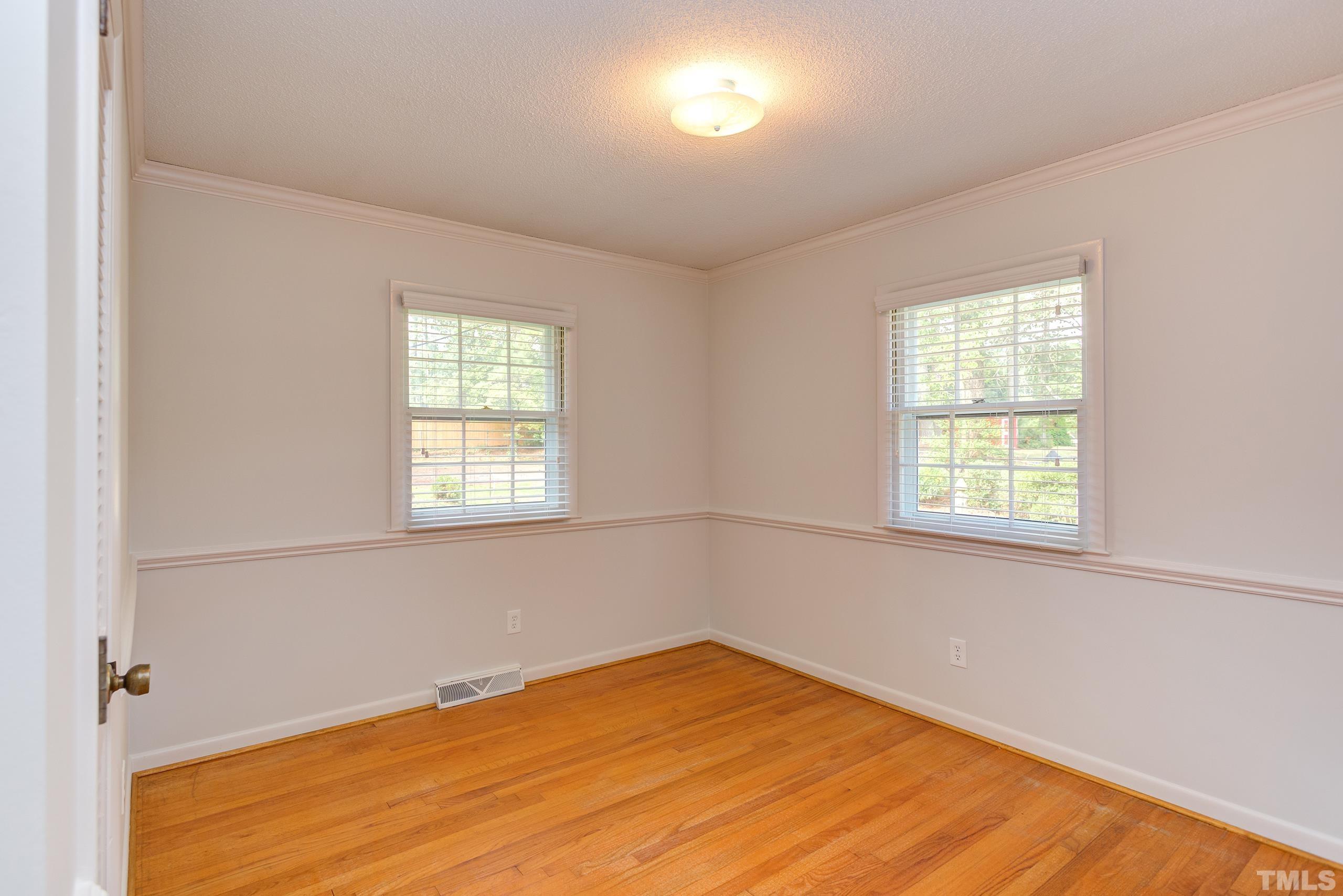 2312 Gresham Lake Road Raleigh, NC 27615 - Photo 24 of 46 a view of an empty room with wooden floor and a window